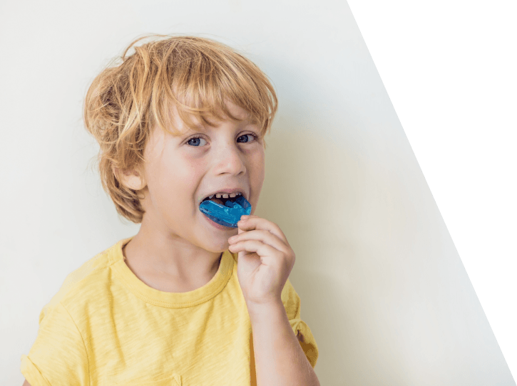 Child placing a blue athletic mouthguard