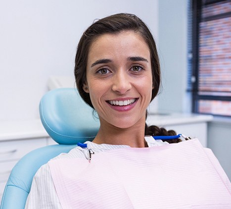 Woman sitting in dental chair and smiling