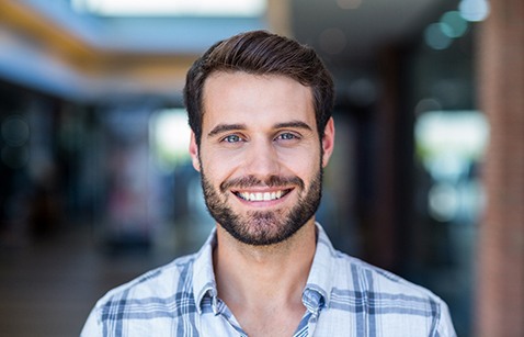 Bearded man with collared shirt smiling