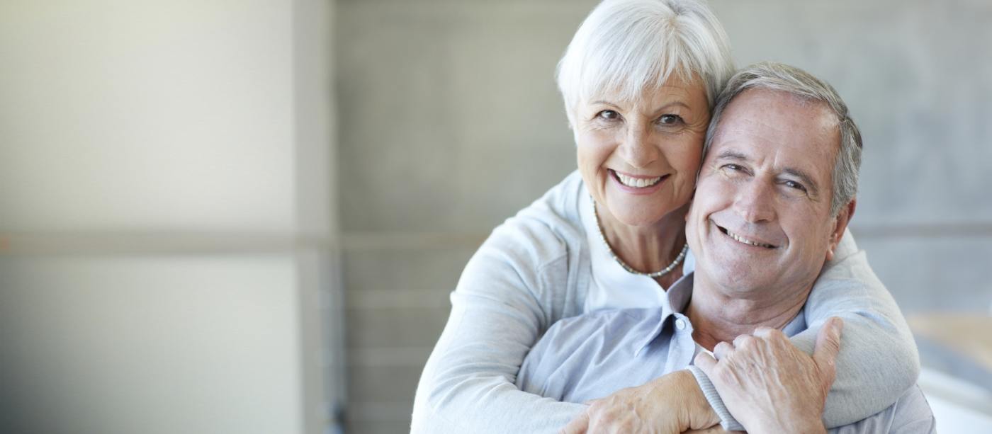 Man and woman smiling after tooth replacement with dental implants