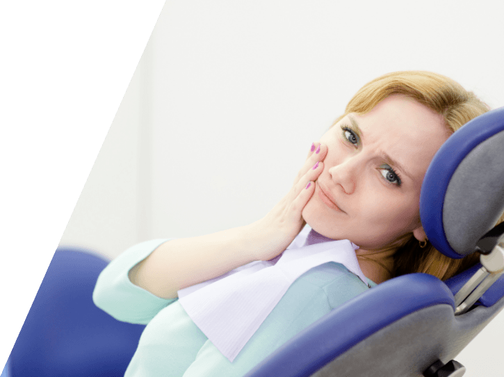 Woman holding cheek in pain during emergency dentistry visit
