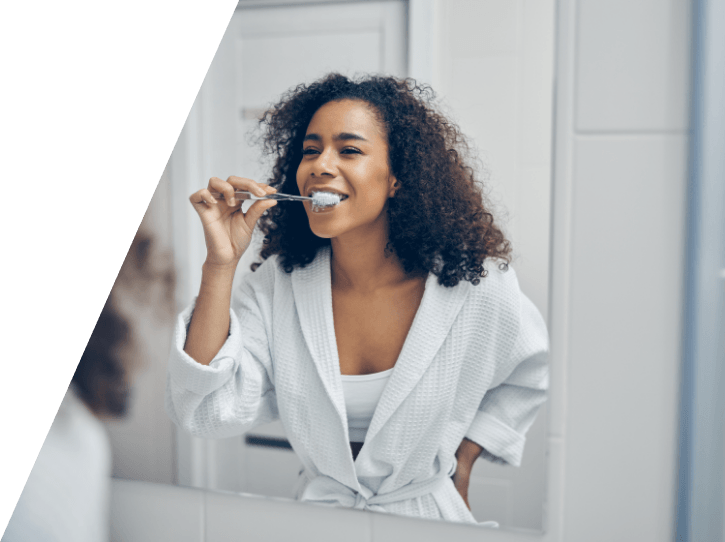Woman brushing teeth to prevent dental emergencies