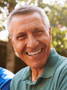 Man smiling after replacing missing teeth