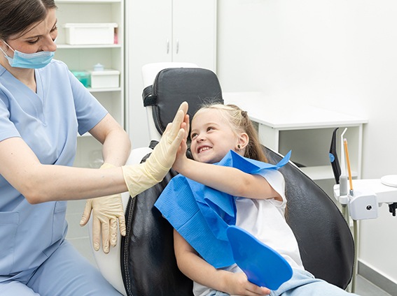 Young child high-fiving dental team member