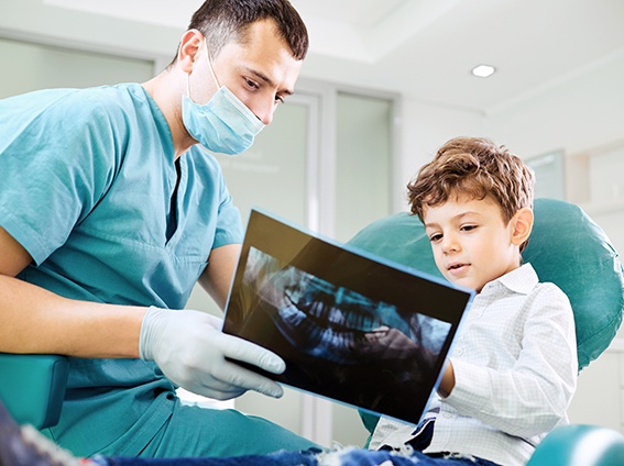Dentist and child patient looking at X-ray together