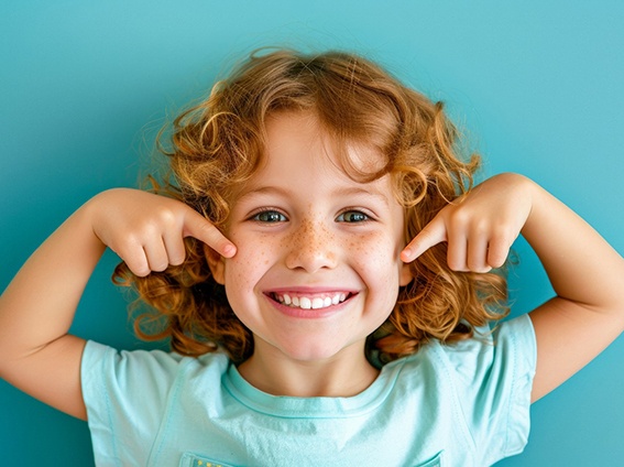 Happy child pointing at their teeth